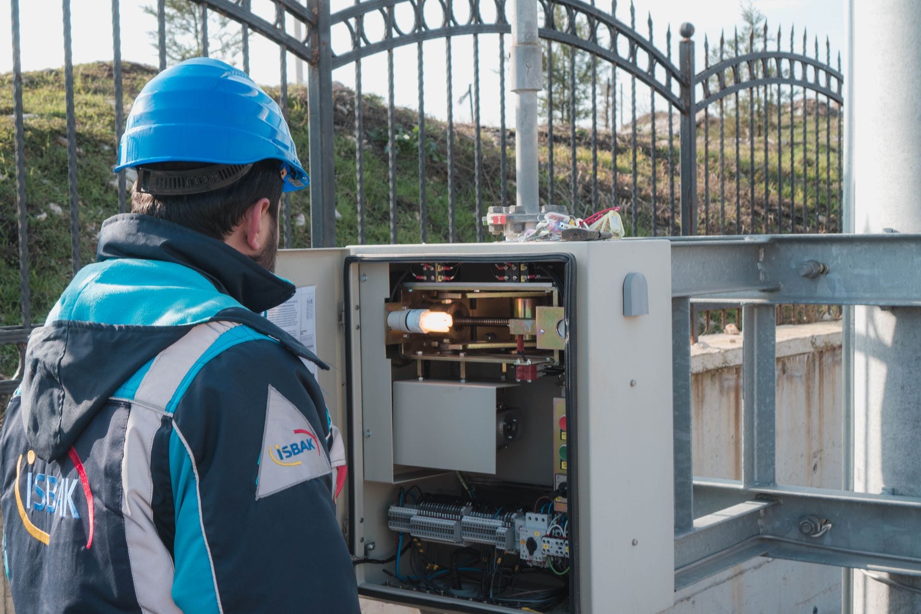 An electrician inspecting an outdoor fuse box